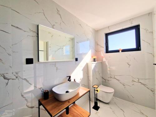 a bathroom with a sink and a toilet and a mirror at Luxury Villa Triton in Novalja
