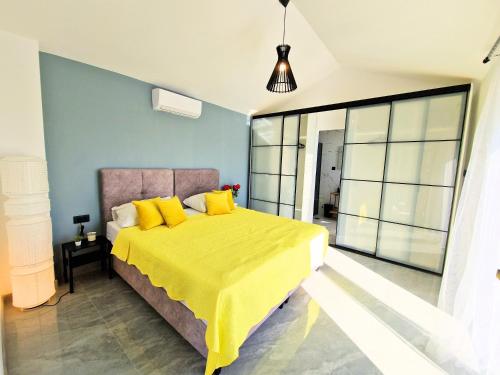 a bedroom with a large yellow bed with yellow pillows at Luxury Villa Triton in Novalja