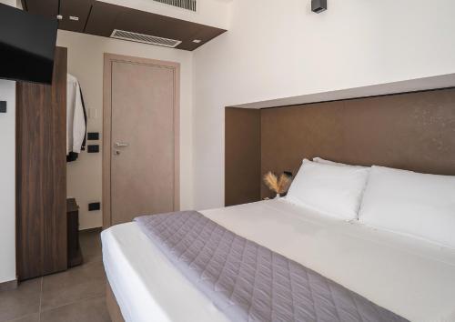 a bedroom with a large white bed and a door at Residence Goldoni6 Suite Apartment in Rimini