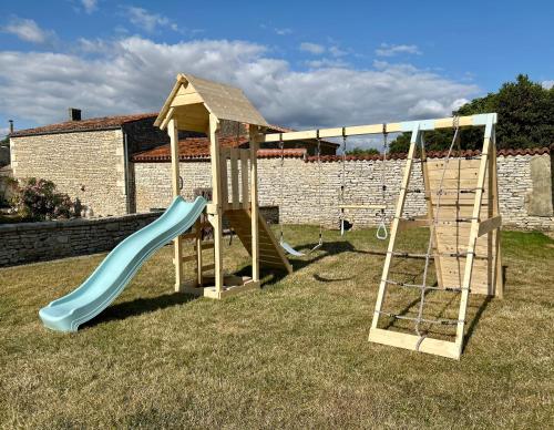 a playground with two swings and a slide at La Barauderie , chambre individuelle in Mazeray