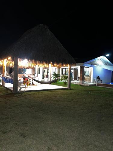 a resort at night with a hammock and a building at Villa Esmeralda del Mar in Monte Gordo