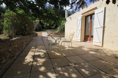 un patio avec des chaises et une table sur un trottoir dans l'établissement Superbe rez de jardin avec aperçu mer et parking, à La Cadière-dʼAzur