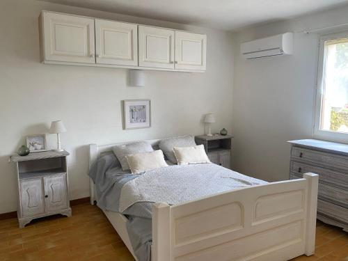 - une chambre avec un lit avec des placards blancs et une fenêtre dans l'établissement Superbe rez de jardin avec aperçu mer et parking, à La Cadière-dʼAzur