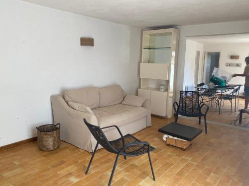 un salon avec un canapé, des chaises et une table dans l'établissement Superbe rez de jardin avec aperçu mer et parking, à La Cadière-dʼAzur