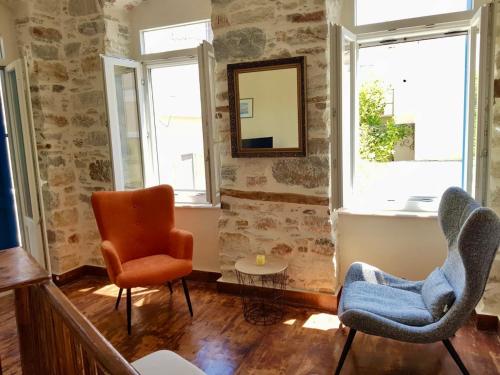 a living room with two chairs and a mirror at Casa Eleni in Ermoupoli