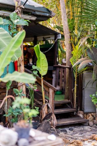 a small house with stairs in a garden with plants at Fare Club Moorea in Motu Tiahura