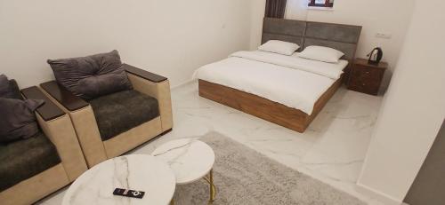 ein Schlafzimmer mit einem Bett, einer Couch und einem Sessel in der Unterkunft Hotel SLY in Goris