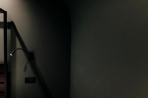 a dark room with a lamp on the wall at CefaLux - Apartments in Cefalù