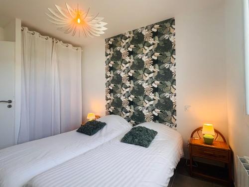 une chambre avec deux lits et un lustre dans l'établissement Maison neuve 4 etoiles à 10 minutes de Royan, à Le Chay