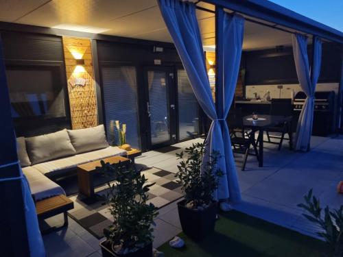 a living room with a couch and a table on a balcony at Mobile home Marina in Drage