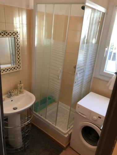 une salle de bain avec douche et lavabo et une machine à laver dans l'établissement T2-terrasse coup de coeur, à Toulon
