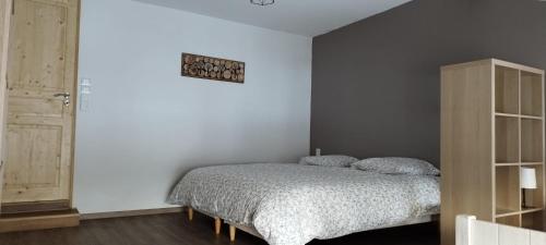 une chambre avec un lit dans une pièce blanche dans l'établissement 8 pers, Maisonnette en bordure de forêt vosgienne, à Barbey-Séroux