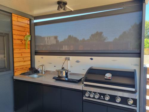 a kitchen with a stove and a large window at Mobile home Marina in Drage