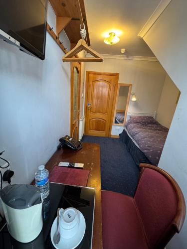 a small room with a bed and a desk in a room at The Villa Hamilton in Hamilton