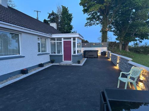 a house with a pink door and a patio at Carlingford View in Kilkeel
