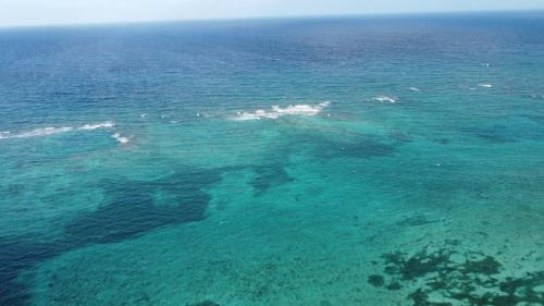 an aerial view of the ocean with reefs at Nirvana Maya in Mahahual