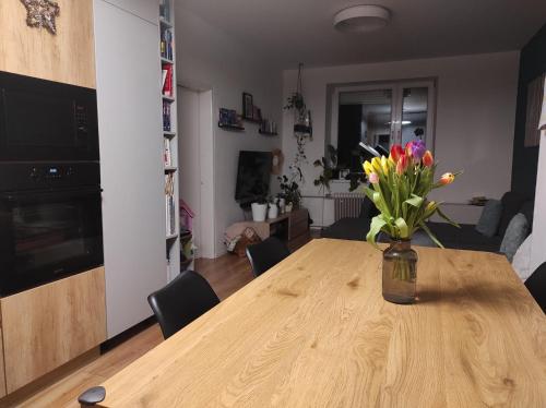 a vase of flowers on a wooden table in a living room at Dovolenkovy dom s terasou in Spišská Nová Ves