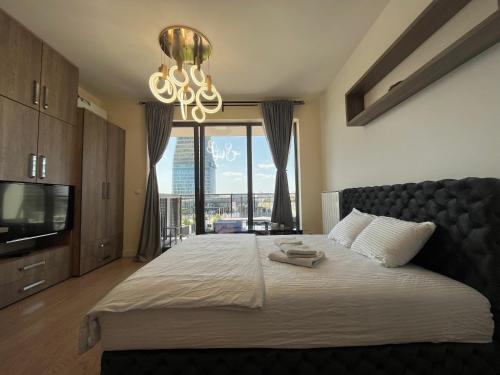 a bedroom with a large bed and a chandelier at Aqua BW Apartments in Sajmište