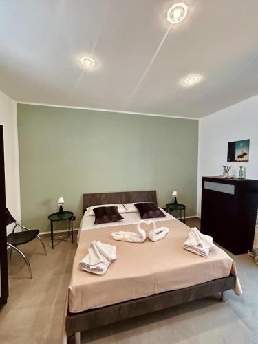 a bedroom with a large bed with towels on it at Il Glicine Casa Vacanze in Augusta