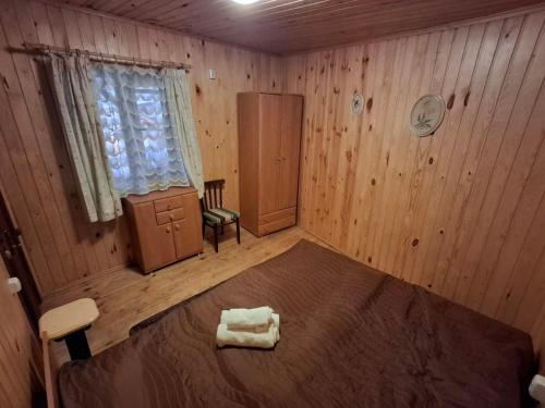 a bedroom with a bed in a wooden room at Садиба Орисин Явір Orysyn Yavir in Svityazʼ
