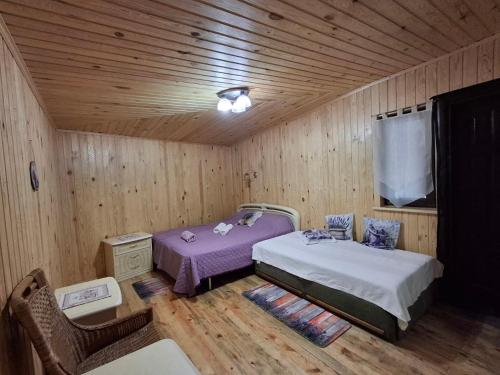 a bedroom with two beds in a wooden room at Садиба Орисин Явір Orysyn Yavir in Svityazʼ