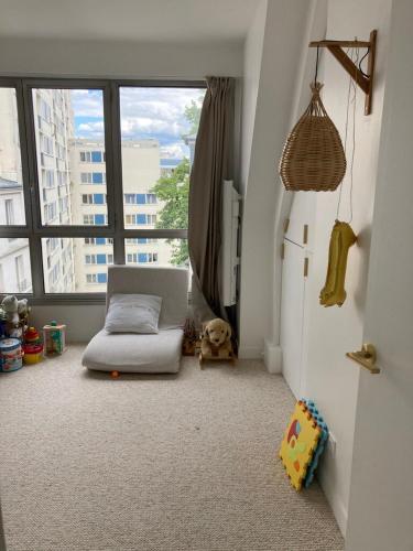 Cette chambre comprend un lit, un réfrigérateur et une fenêtre. dans l'établissement Beautiful kids friendly apartment with Montmartre view, à Paris