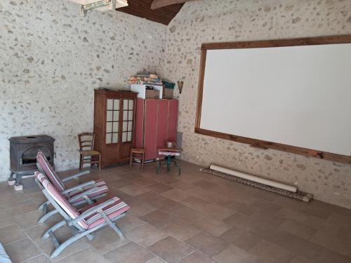 a room with two chairs and a large window at Ferme de la Ruaudiére Courdemanche in Courdemanche
