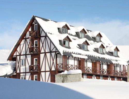 une maison recouverte de neige dans la neige dans l'établissement Edelweiss Hotel, à Goudaouri