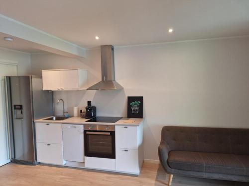 a kitchen with a stove top oven next to a couch at Fjord Nest in Bergen