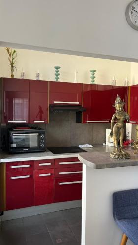 une cuisine avec des armoires rouges et un micro-ondes dans l'établissement Two Bedroom Apartment near Old Town, à Nice