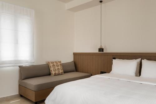 a bedroom with a bed and a couch at Dolphin Bay Seaside Resort & Suites in Galissas