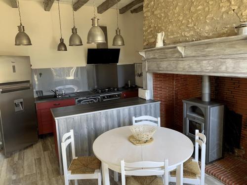une cuisine avec une table et une cuisinière dans l'établissement Gîte de charme en Périgord, à Milhac-dʼAuberoche
