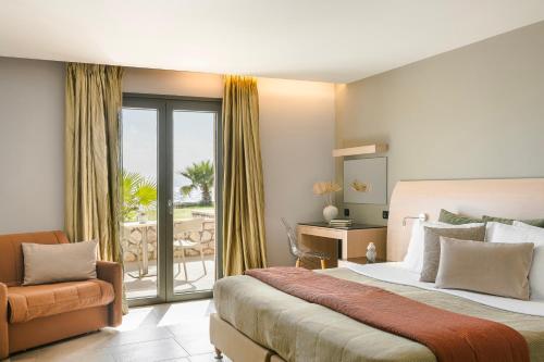 a hotel room with a bed and a balcony at Alas Resort & Spa in Elia Laconias