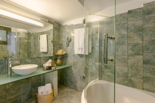 a bathroom with a tub and a sink at Alas Resort & Spa in Elia Laconias