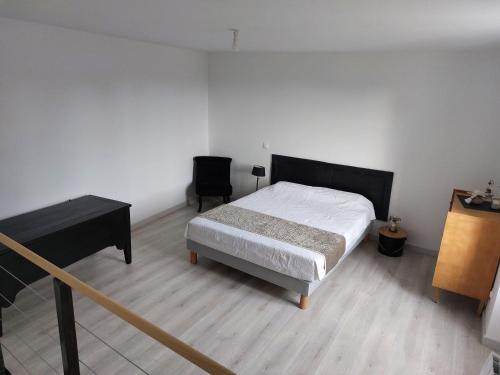 ein Schlafzimmer mit einem Bett, einem Schreibtisch und einem Klavier in der Unterkunft le gîte AGVP in Civaux