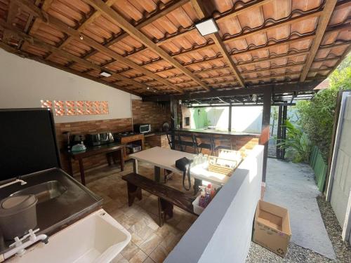 a kitchen and dining room with a table and a sink at Cantinho de São Chico in São Francisco do Sul