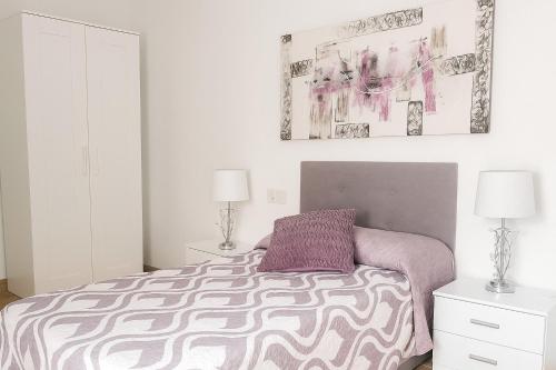 a bedroom with a bed with a purple pillow at Casa Julita con Parking in Elche