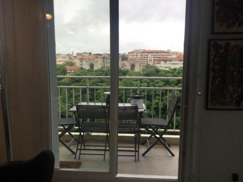 une vue d'un balcon avec une table et des chaises dans l'établissement 3 chambres au coeur de biarritz, à Biarritz