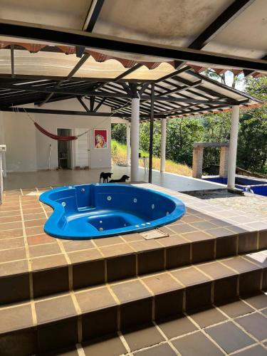 a blue tub sitting on a tile floor under a pavilion at Finca de Majo in Mocoa