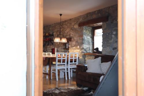 a kitchen and dining room with a stone wall at Cal Gano, 3-Story Stone & Wood Mountain Retreat in Llo