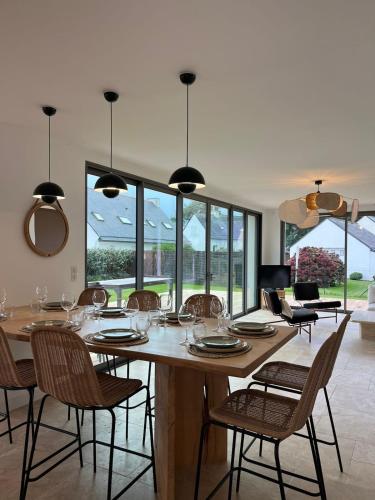 une salle à manger avec une grande table et des chaises en bois dans l'établissement Maison Guelan Kerners, à Arzon