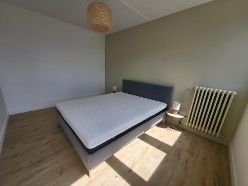 - une petite chambre avec un lit et un radiateur dans l'établissement Adamo, au Mans