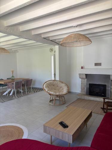 un salon avec une table et une cheminée dans l'établissement Maison 3 chambres avec jardin, à Eymet