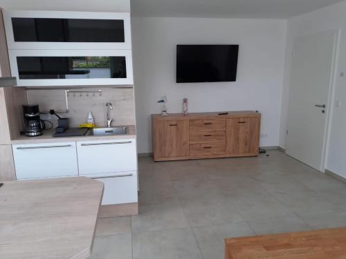 a kitchen with white cabinets and a flat screen tv at Marktperle in Sagard