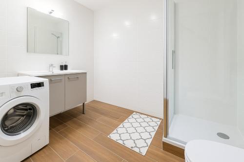 a white laundry room with a washer and dryer at Le Cocon - Vue panoramique Strasbourg - Wifi - Netflix in Strasbourg