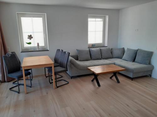 a living room with a couch and tables and two windows at Marktperle in Sagard