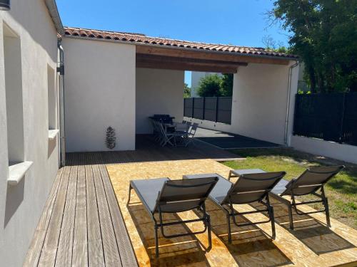 un patio con tavolo e sedie su un ponte di Maison moderne plain-pied 3 chambres jardin préau a La Rochelle