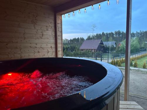 a large tub filled with red liquid next to a window at Stodoła Sople 2 in Sople
