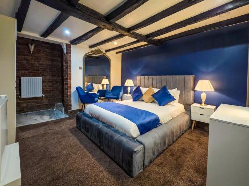 1 dormitorio con 1 cama grande y paredes azules en The Courtyard Lodge, en Hitchin