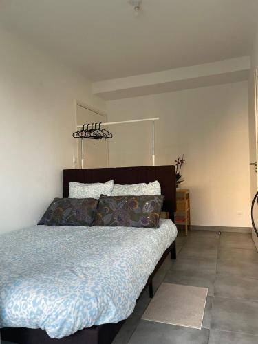 une chambre avec un lit avec une couette bleue dans l'établissement Petit cocon Sètois ! Balcon avec vue et parking, à Sète